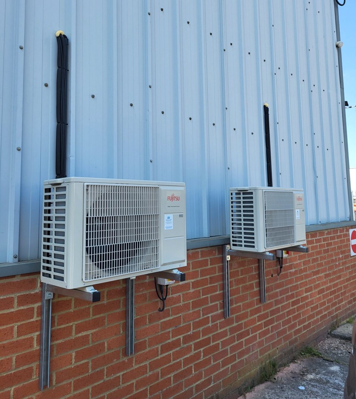 Fujitsu air conditioning units on the exterior of a factory building