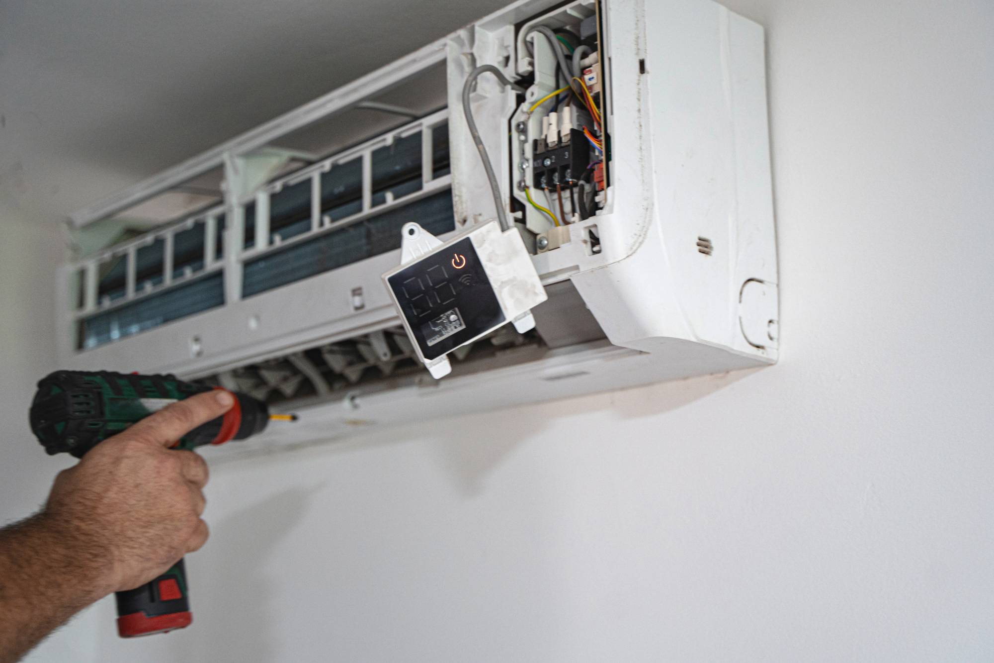 Air conditioning unit with the front removed being installed with a pneumatic drill